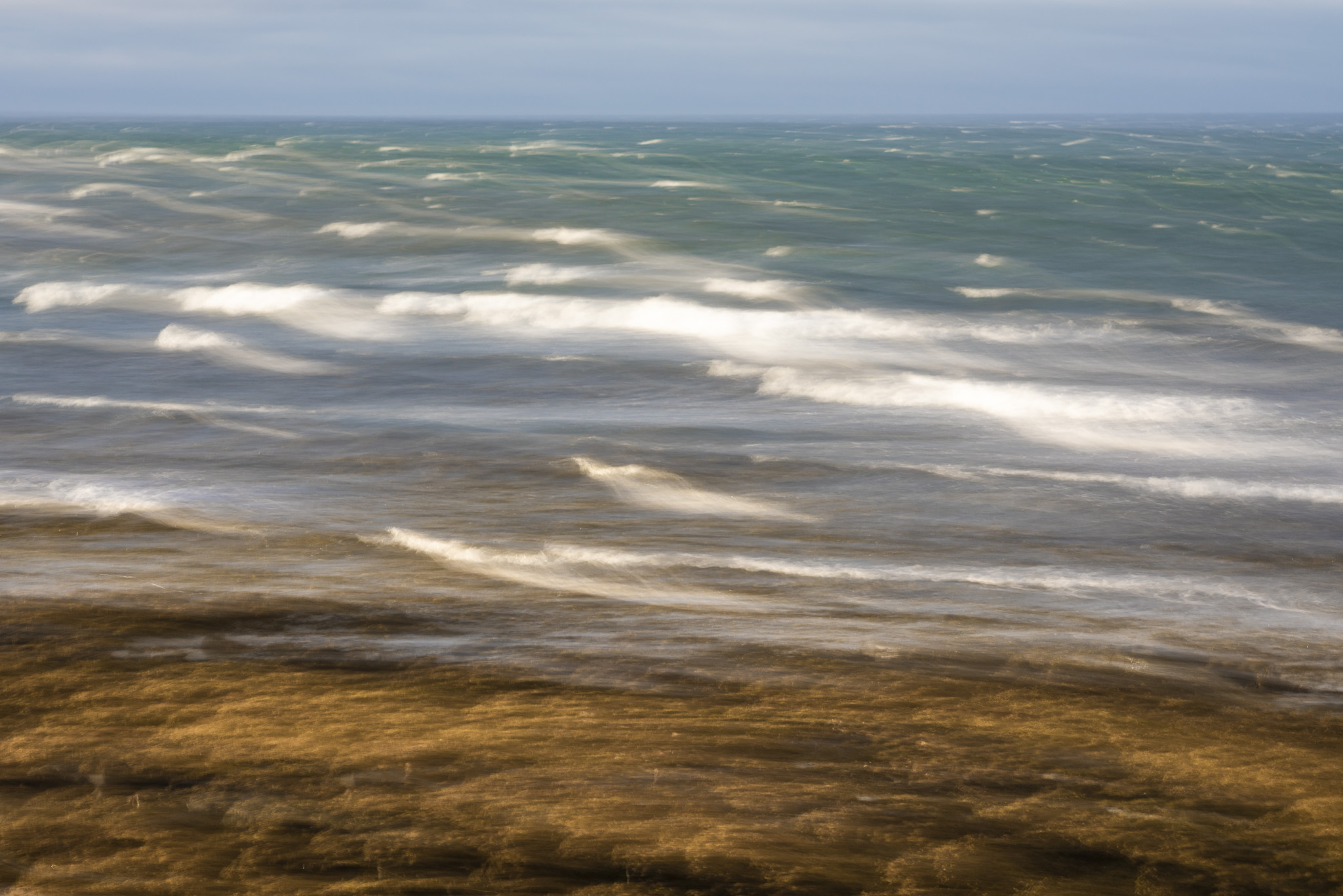 Abstraktes Bild aus Island, Landschaft mit Meer wo sich Wellen brechen.