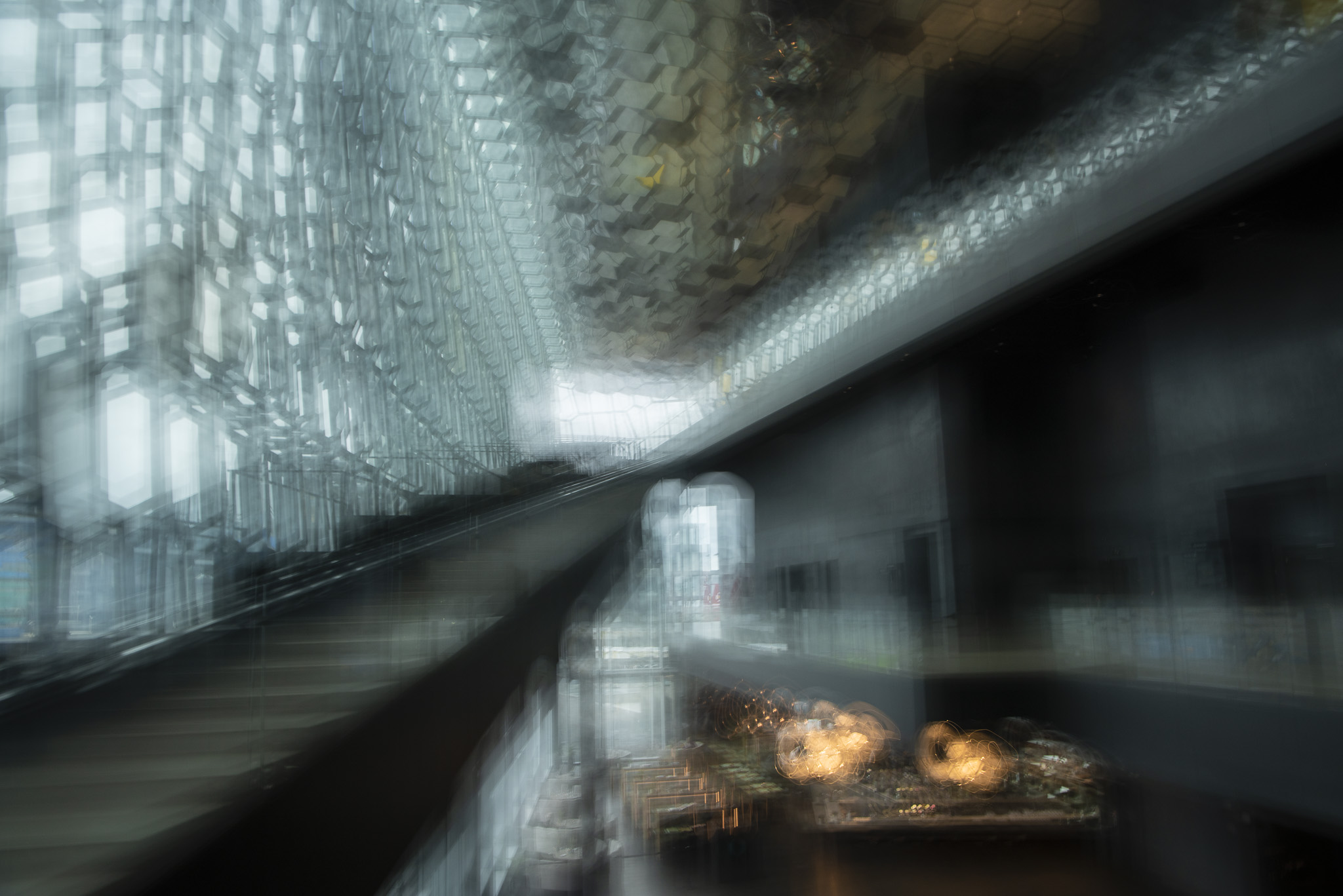 Abstraktes Bild vom Harpa im Innenbereich mit goldenem Licht aus dem Restaurantbereich.