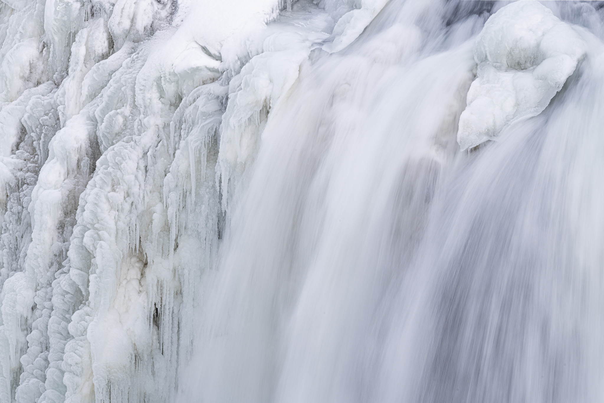 Eisstrukturen sowie fließendes Wasser in teilweise angefrorenen Gullfoss Wasserfall in Island.
